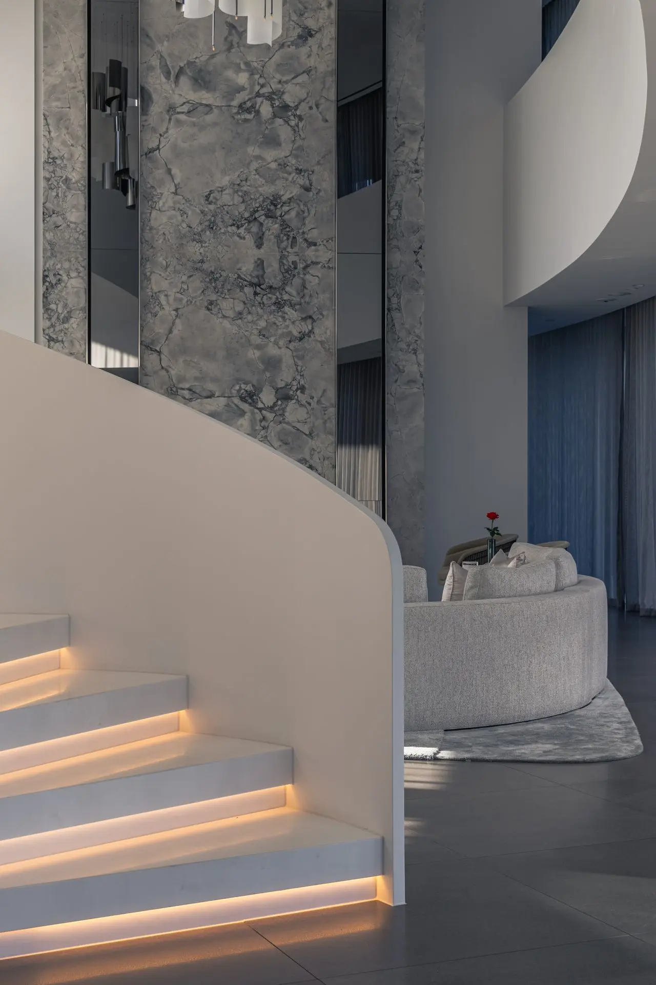 Three-storey Superwhite Dolomite lift core with seamless vertical panels and mitred detailing.