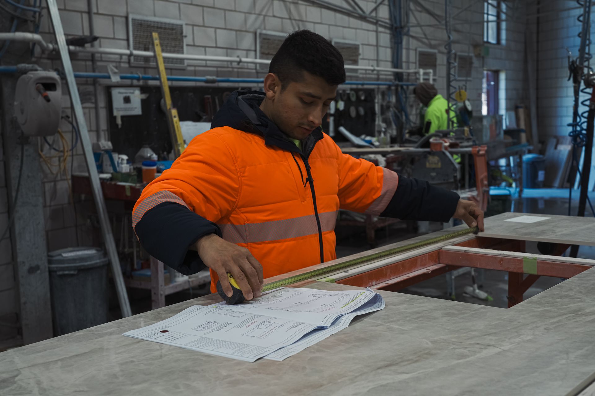 Artisan stonemason hand-finishing marble edges for flawless polish and tight tolerances.